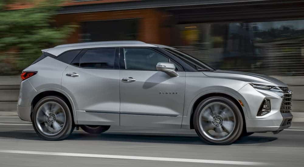A silver v is driving down a city street.