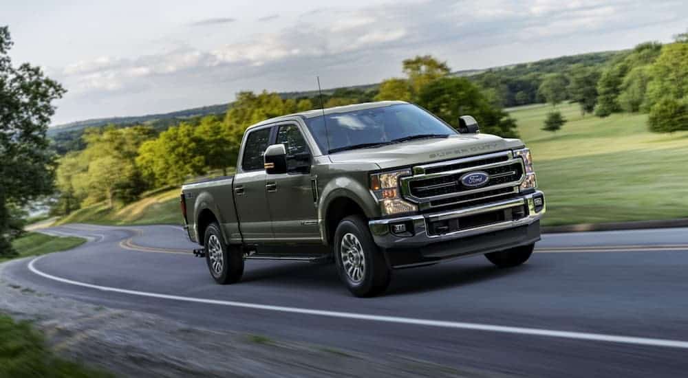A grey 2020 Ford F-250 is driving on a winding road.