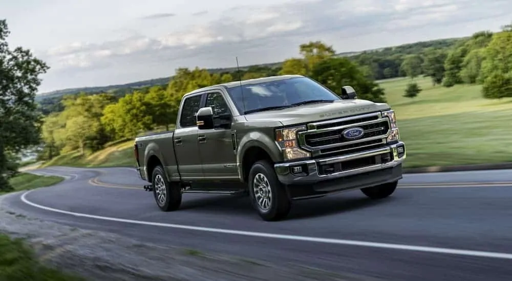 A grey 2020 Ford F-250 is driving on a winding road.