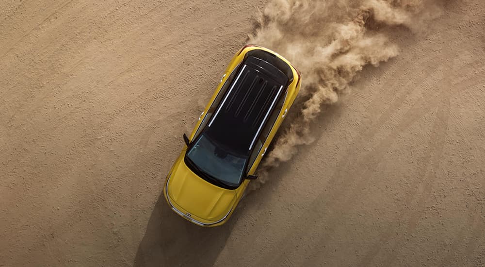 A yellow 2021 Kia Seltos is shown from above drifting in sand after winning the 2021 Kia Seltos vs 2020 Ford EcoSport comparison.
