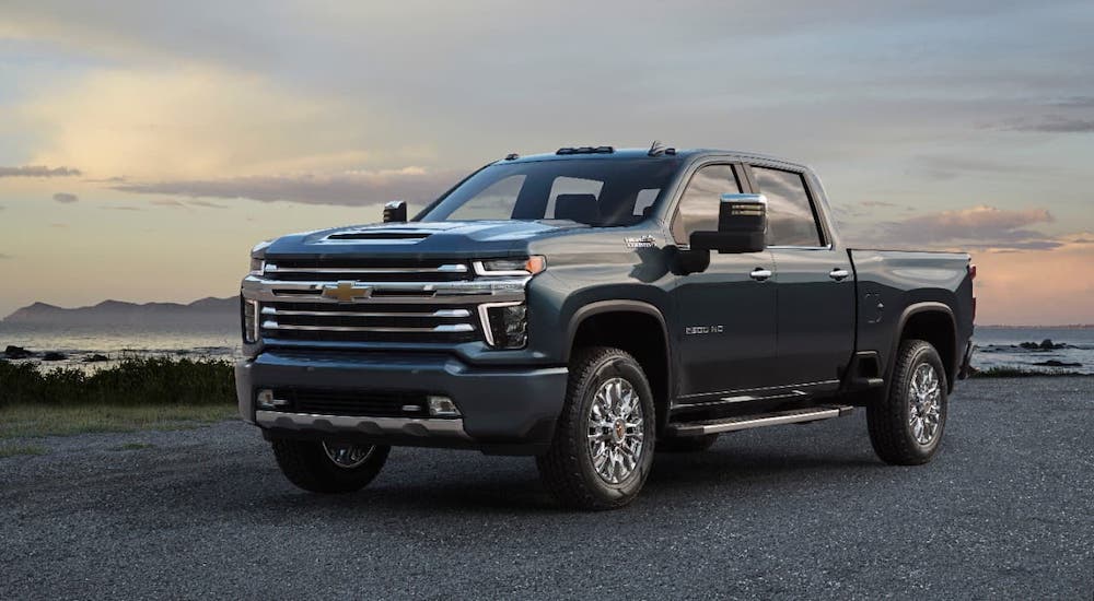 One of the popular Chevy truck trims, a dark blue 2020 Chevy Silverado 2500HD High Country is parked in front of a beach.