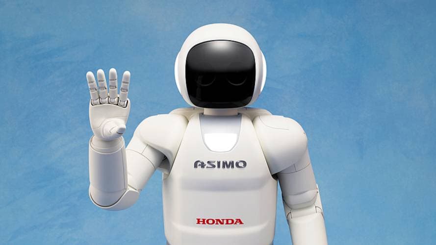 The white humanoid robot ASIMO is waving in front of a blue background.