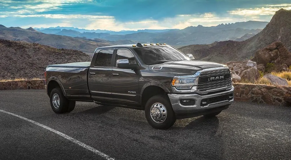 A gray 2020 Ram 3500, which is available from your local Ram dealership, is driving on a highway in front of mountains.