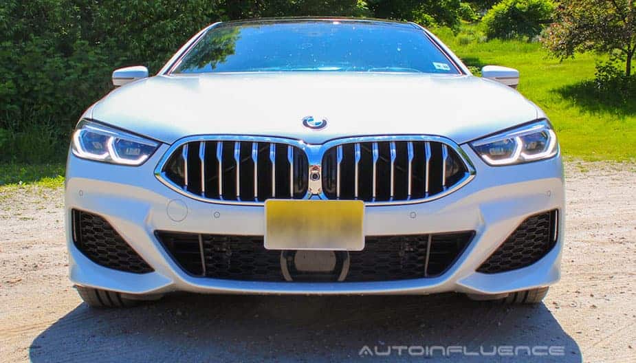 A white 2020 BMW 840i Gran Coupe is shown from the front in a dirt parking lot.