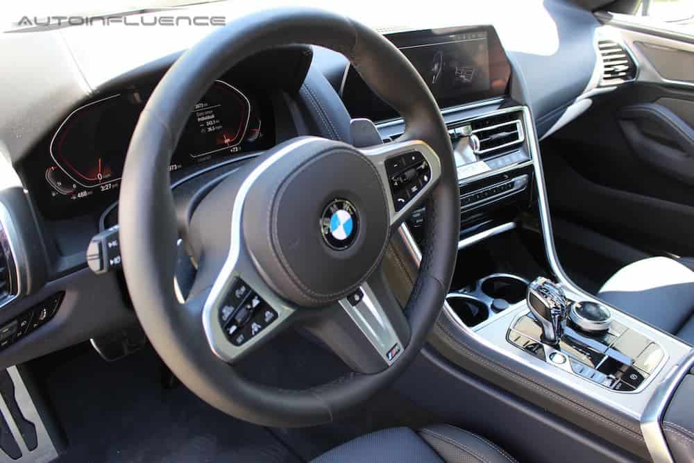 The wheel and infotainment features in a 2020 BMW 840i Gran Coupe are shown.