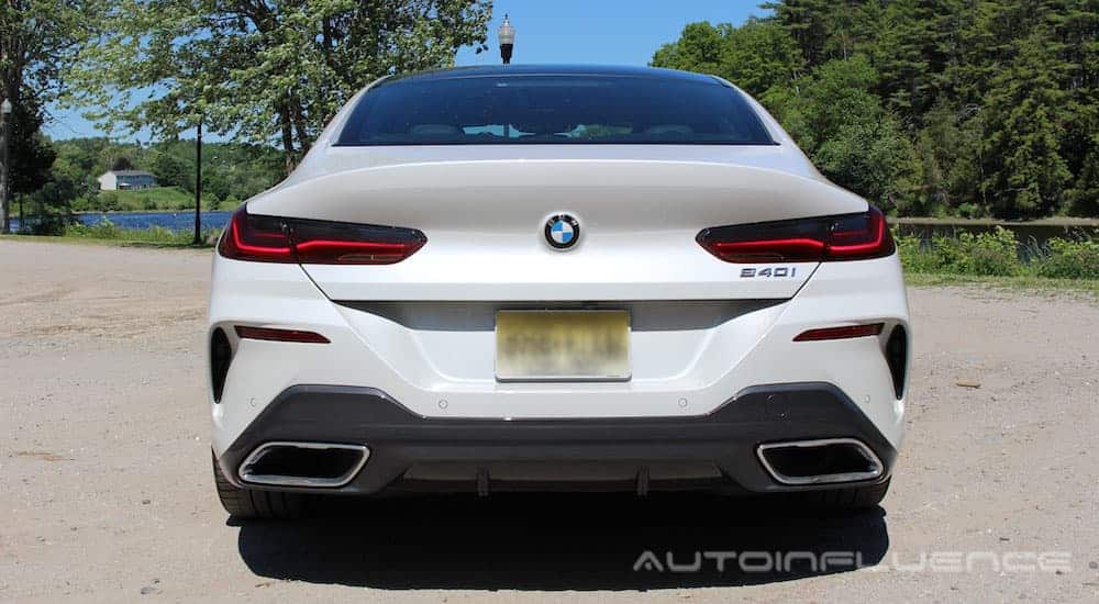 A white 2020 BMW 840i Gran Coupe is shown from the rear in a dirt parking lot.