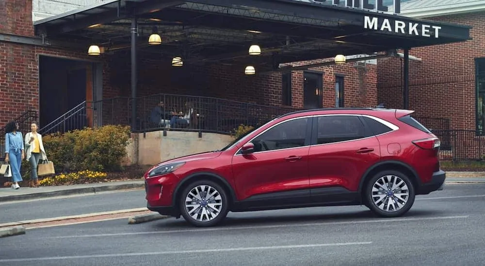 A red 2020 Ford Escape is parked in front of a market.