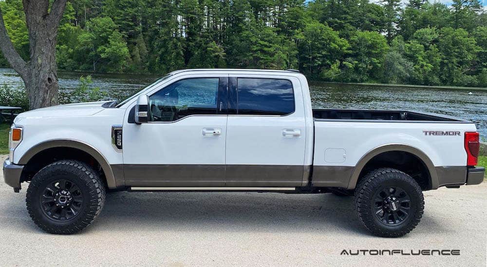 A white 2020 Ford F-250 Super Duty Tremor is shown from the side in front of a river.