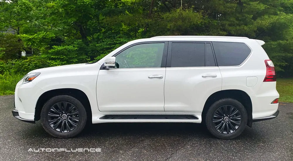 A white 2020 Lexus GX 460 is shown from the side in front of trees.