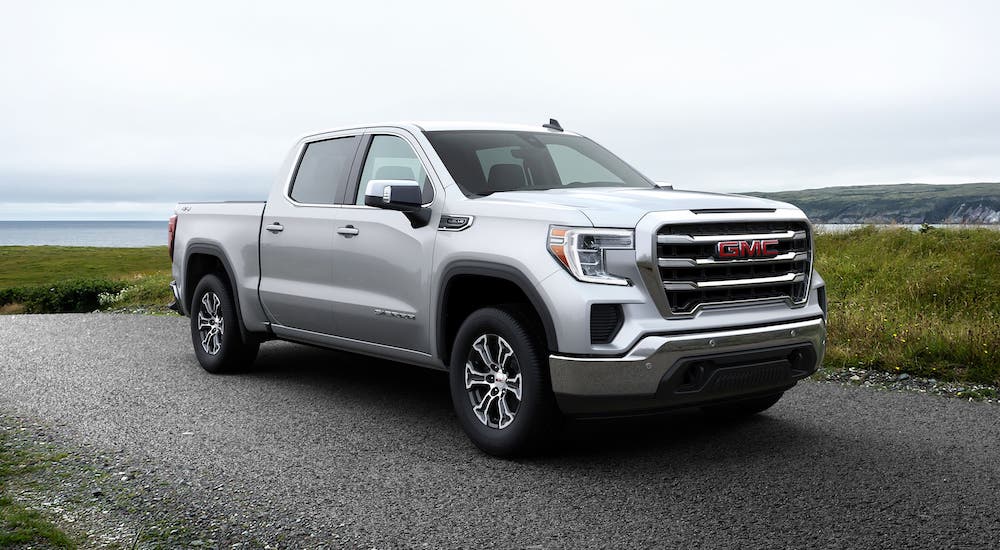 A silver 2020 GMC Sierra 1500 is parked in front of a body of water.