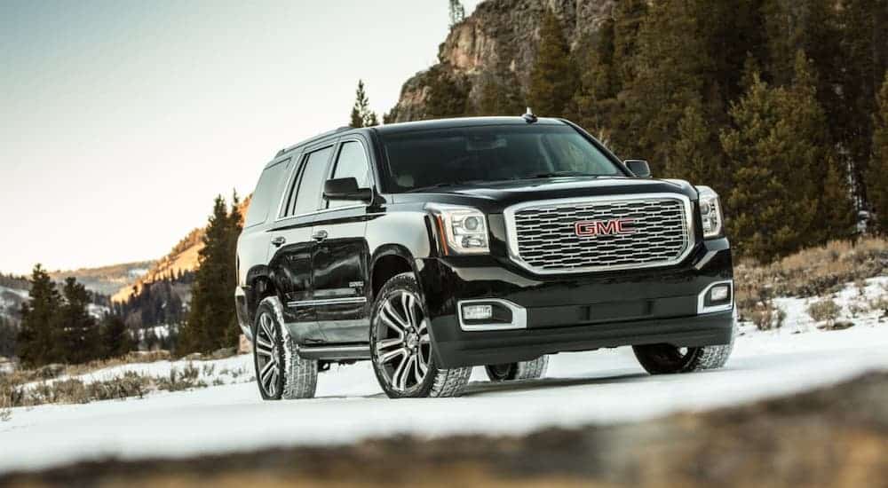 A black 2020 GMC Yukon Denali is parked on a snowy road.