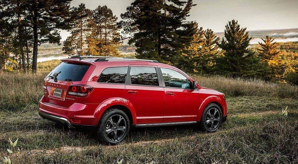 A red 2020 Dodge Journey is driving on a dirt trail.