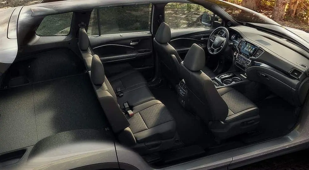 A cutaway shows the black interior and cargo area of silver 2020 Honda Passport Elite.