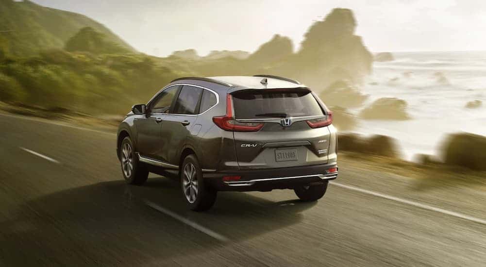 A grey 2020 Honda CR-V, which is popular among Honda models, is driving past land formations in the ocean.
