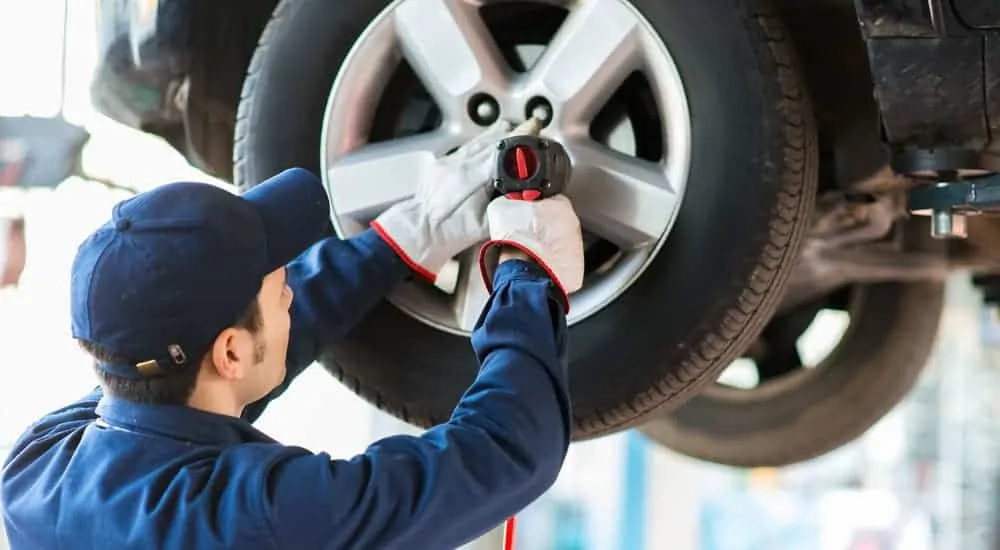 A mechanic is tightening the lug nuts on a car.