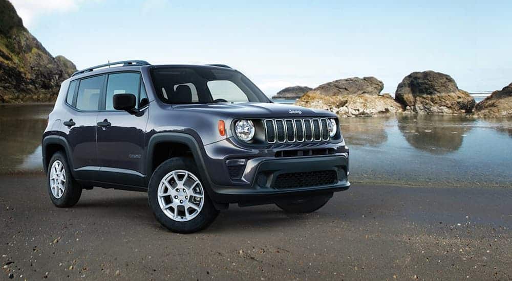 A 2020 Jeep Renegade is parked on the sand at the beach.