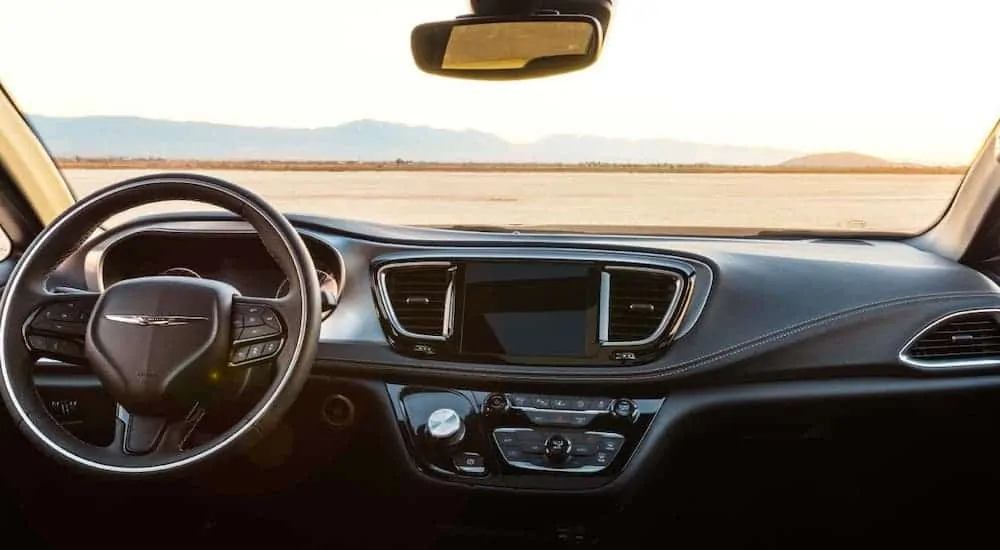 The black dashboard and interior of a 2020 Chrysler Pacifica is shown.