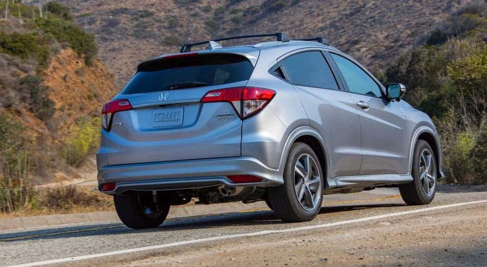 A silver 2020 Honda HR-V is driving on a mountain highway.