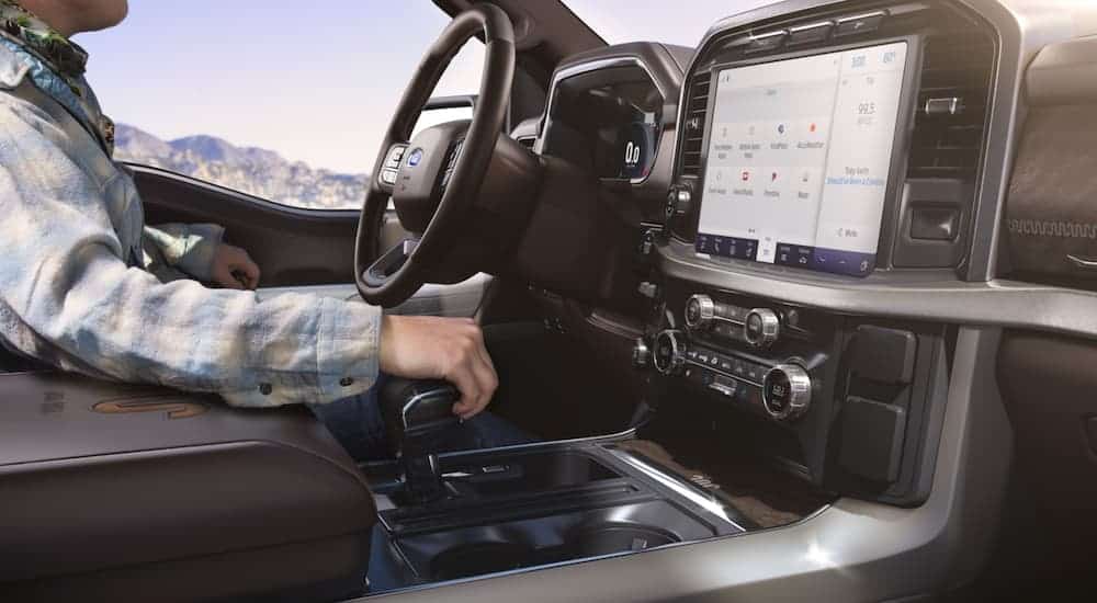 The screen in a 2021 Ford F-150 is shown with a person in the driver's seat.
