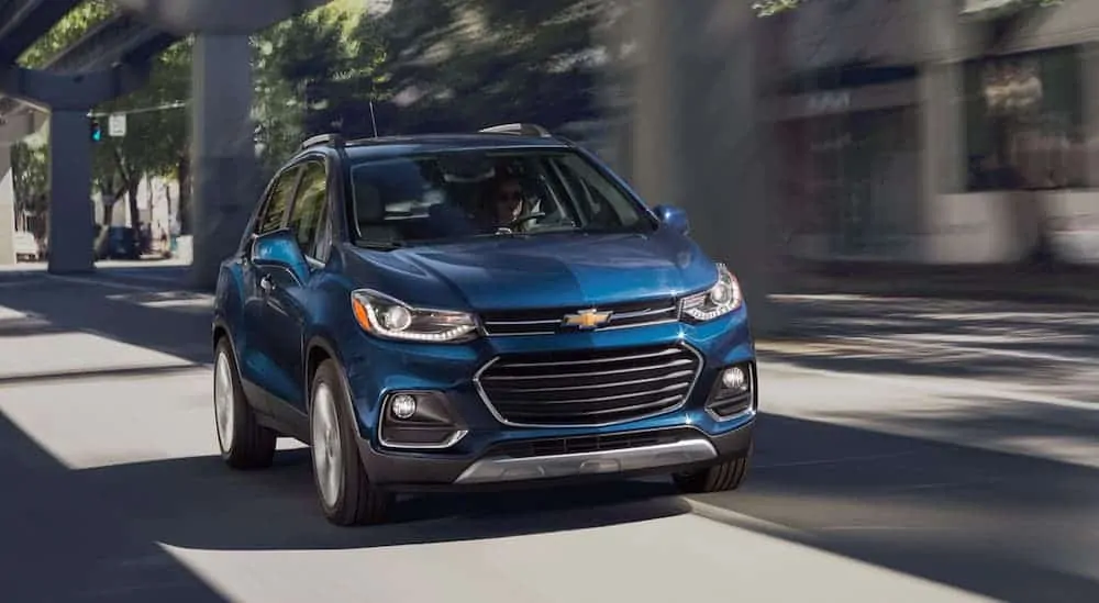 A blue 2020 Chevy Trax is driving down a city street.