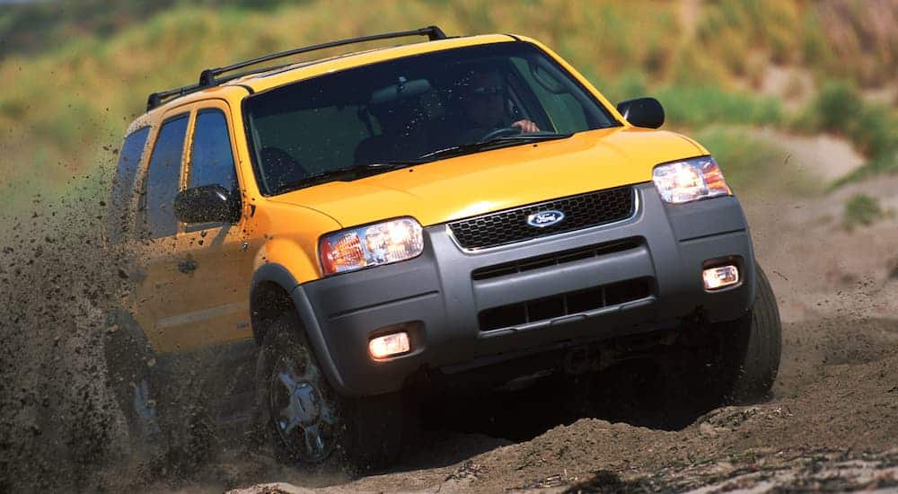 A yellow 2001 used Ford Escape is off-roading in the dirt.