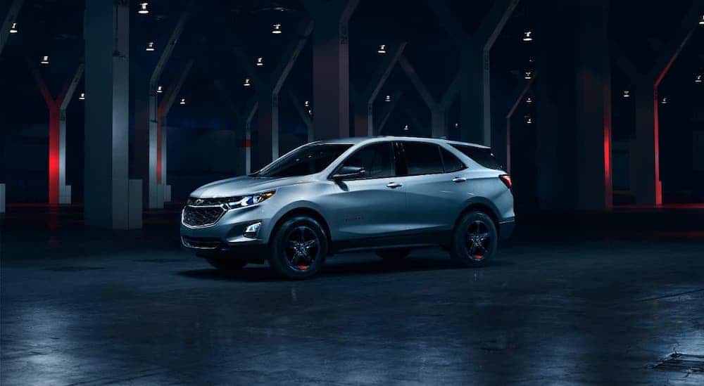 A silver 2020 Chevy Equinox Redline Edition is parked in a warehouse.