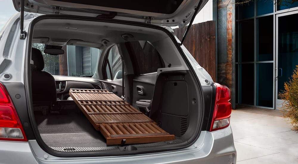 A table is shown loaded into the cargo area of a silver 2020 Chevy Trax.