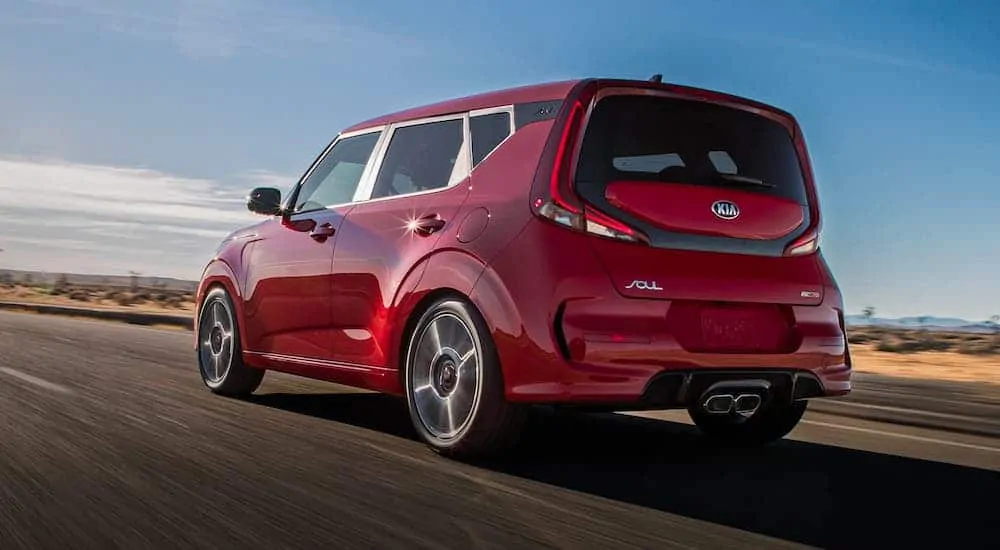 A red 2020 Kia Soul is shown driving away on a highway after losing the 2020 Chevy Trax vs 2020 Kia Soul comparison.