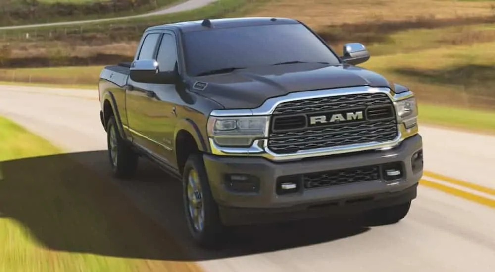 A grey 2020 Ram 2500 Limited is driving past fields.