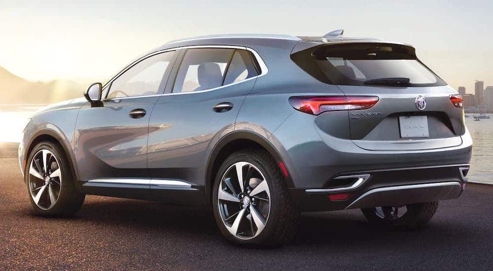 A silver 2021 Buick Envision is parked in front of a river and shown from behind.