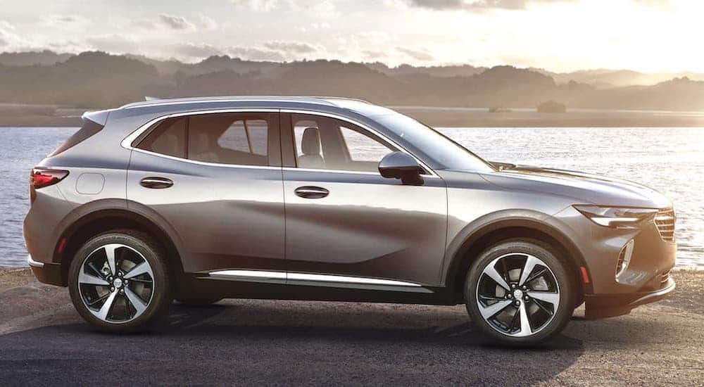 A silver 2021 Buick Envision is parked in front of a river and shown from the side.