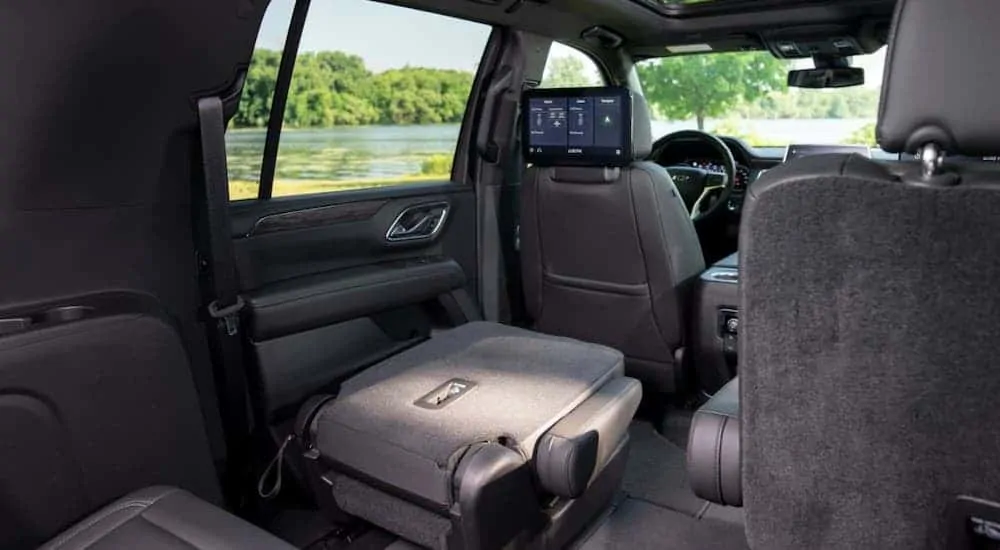 A folded middle seat is shown inside a 2021 Chevy Suburban from the cargo area.