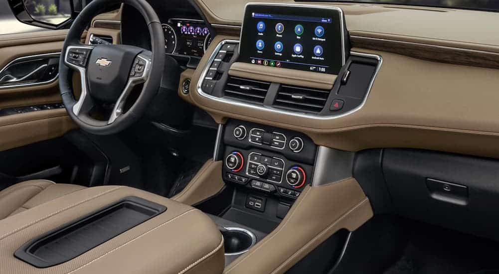 The tan interior and touch screen are shown in a 2021 Chevy Suburban.