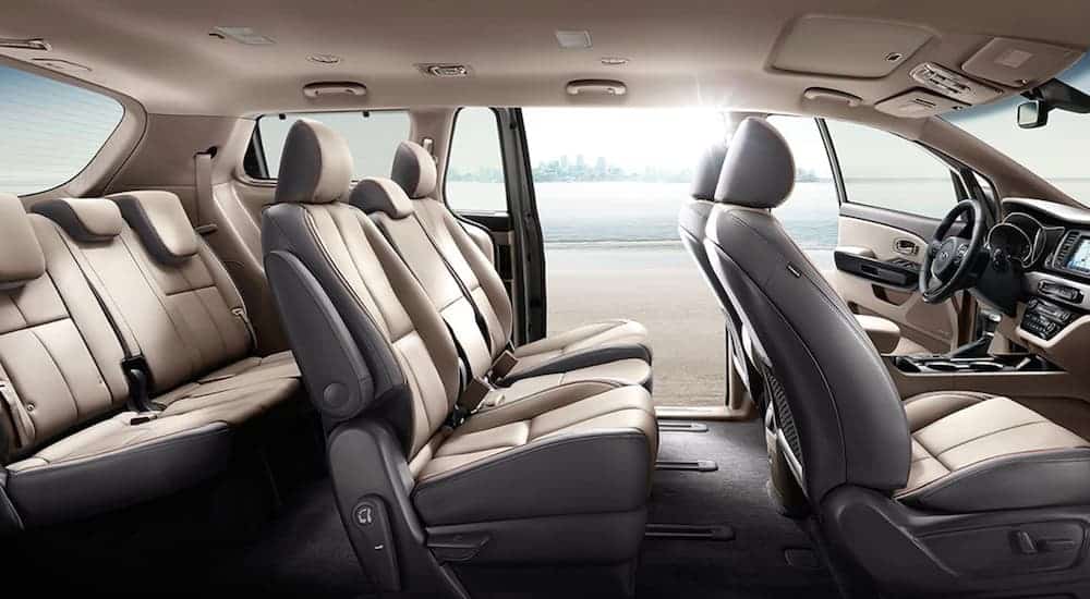 The tan interior of a 2021 Kia Sedona is shown from the side.