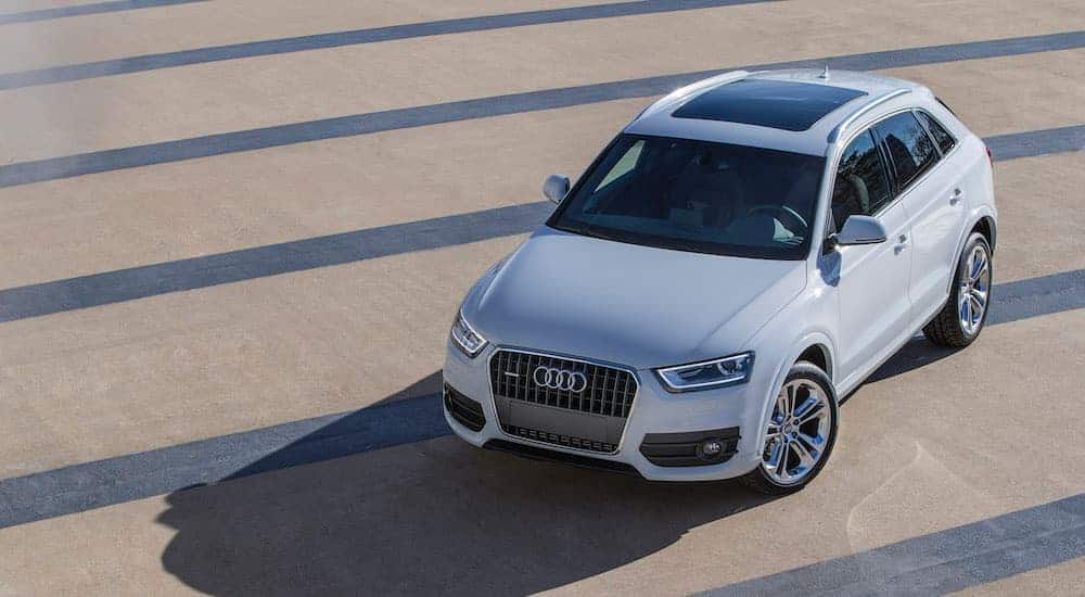A white 2015 Audi Q3 is shown from above in an empty lot.