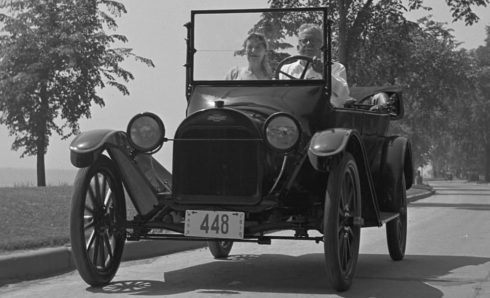 A couple is driving a 1916 Chevy 490, shown in black and white. 