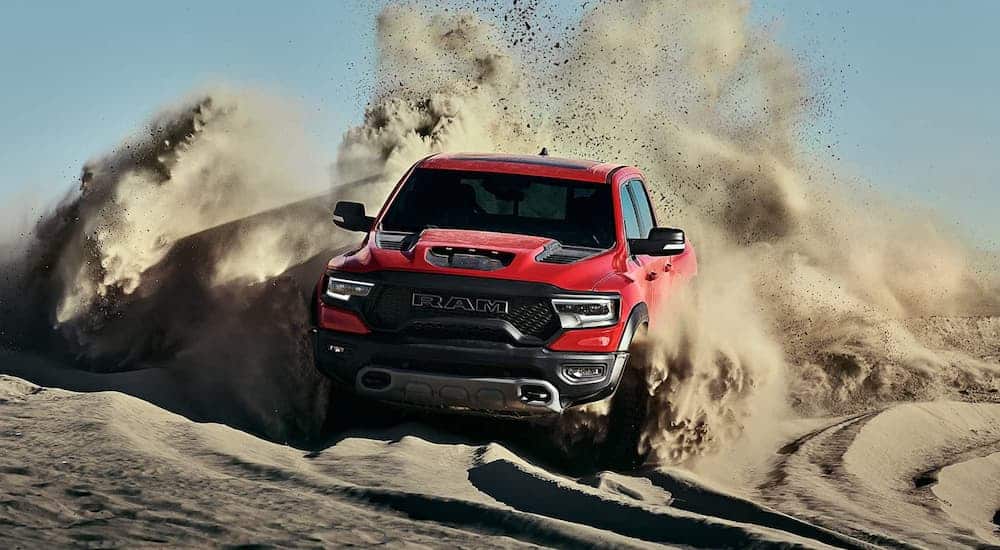 A 2021 Ram 1500 TRX from a Ram dealer is kicking up sand while off-roading.