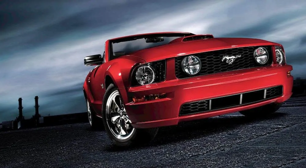 A red 2010 Ford Mustang convertible is shown from a low angle.
