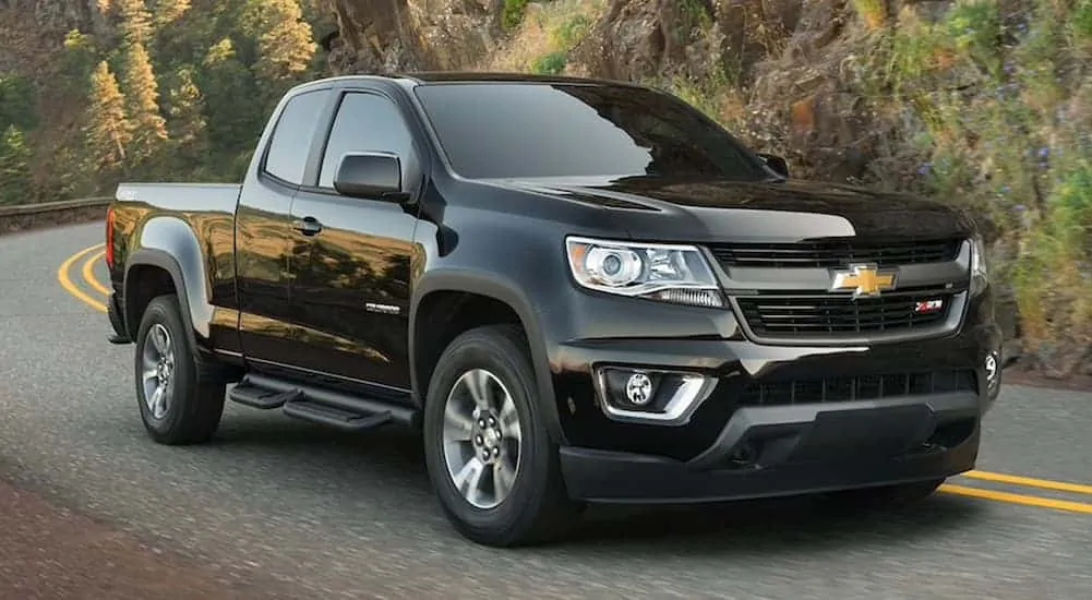 A black 2020 Chevy Colorado is driving on a winding mountain road.