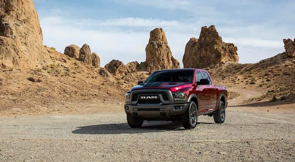 A resurrection of a classic used truck for sale, a red 2019 Ram 1500 Classic Warlock, is parked in front of rock formations.
