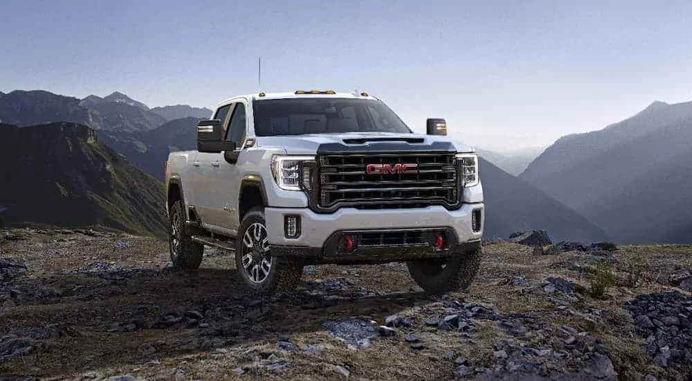 A white 2020 GMC Sierra 2500HD AT4 is parked in the mountains.