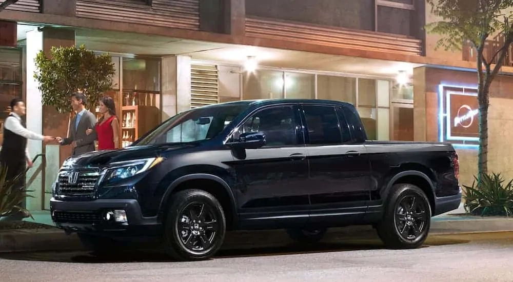 A black 2020 Honda Ridgeline Black Edition is parked outside a restaurant.