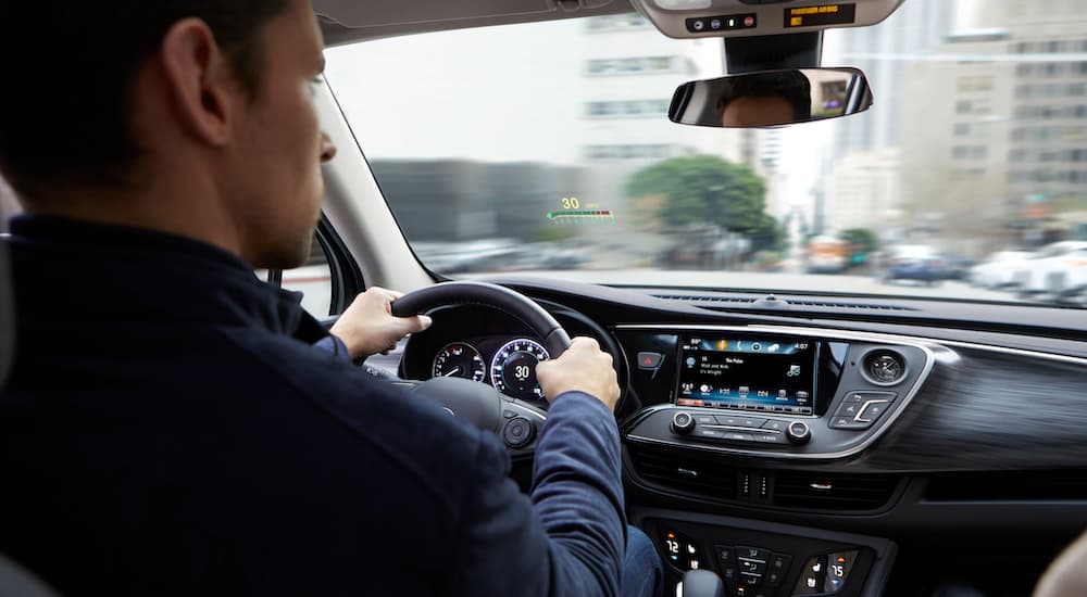 A man is driving a 2020 Buick Envision with head-up display, shown from the interior.