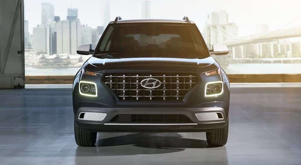 A blue 2021 Hyundai Venue is shown from the front parked in a hangar.