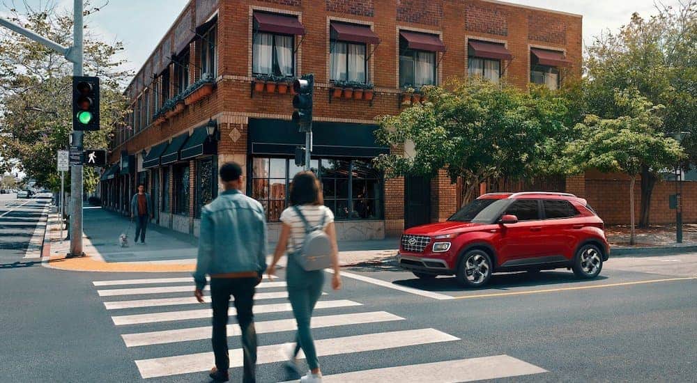 A red 2021 Hyundai Venue is parked in front of a crosswalk.