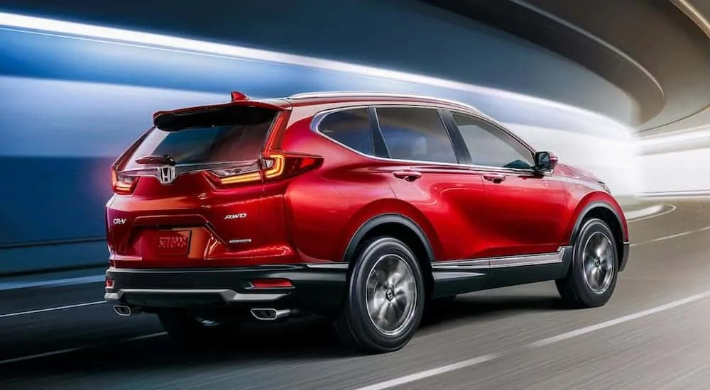 A red 2020 Honda CR-V is driving around a corner.