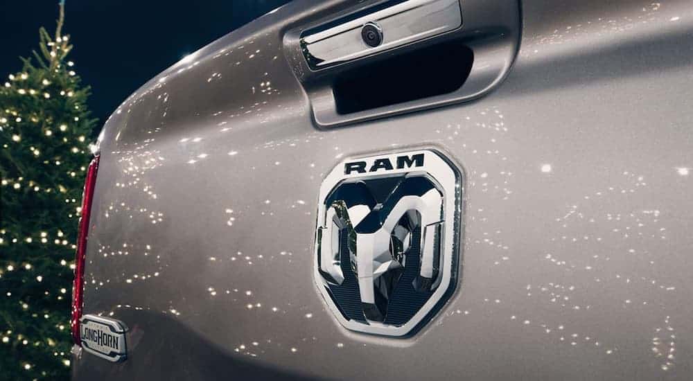 A silver 2020 Ram 1500 Longhorn tailgate is shown with Christmas tree lights reflecting off the paint.