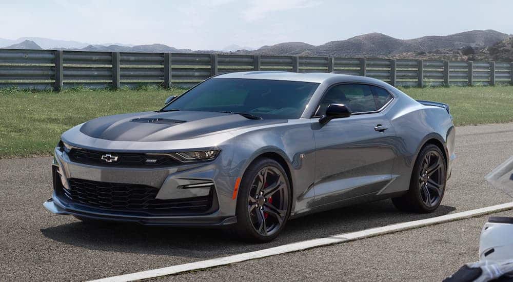 A grey 2021 Chevrolet Camaro SS is parked near a guard rail at the track.