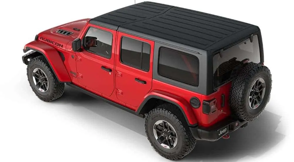 A red 2021 Jeep Wrangler Rubicon is parked angled left with a hard top on.