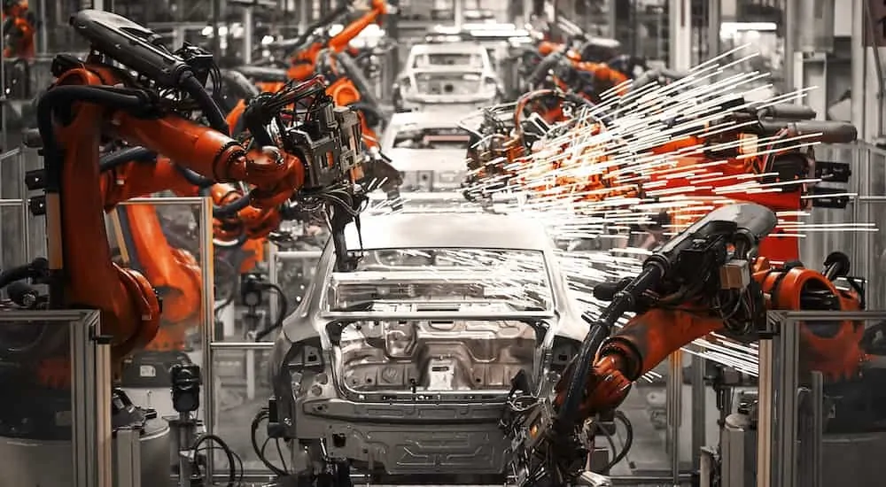An assembly line is shown where car bodies are being welded, these innovative vehicles can be found at a Nissan dealer near you.